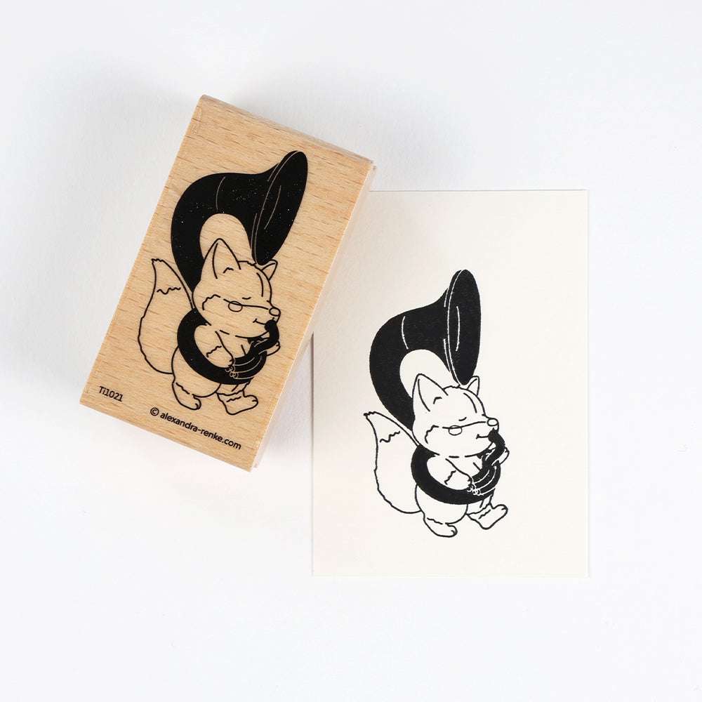 Holzstempel von Alexandra Renke mit einem fröhlichen Fuchs, der Tuba spielt - ideal für kreative Papierprojekte. Das Motiv zeigt den Fuchs voller Freude mit großer Tuba auf weißem Hintergrund.