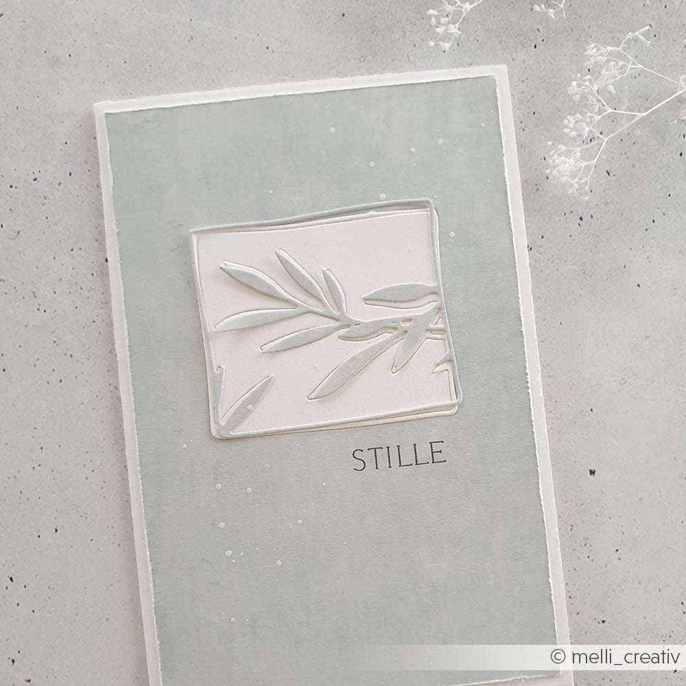 Minimalistische Karte von Alexandra Renke mit geprägtem Blatt und "STILLE" auf zartgrauem Hintergrund, gestaltet mit Beileid Stempel oder Clear Stamps für eine subtile, herzliche Note.
