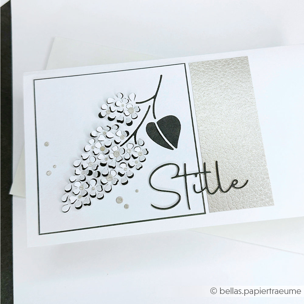 Handgefertigte Karte von Alexandra Renke mit einem floralen Design auf hochwertigem Designpapier, silbernen Akzenten und "Stille" in eleganter Schrift, erstellt mit der Motivstanze Stille.