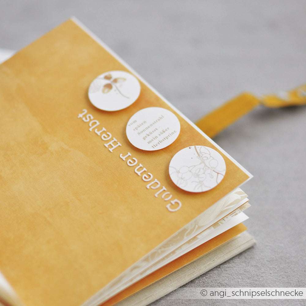 Das gelbe Scrapbook von Alexandra Renke mit dem Titel Glücklicher Herbst hat drei runde Papierausschnitte auf dem Umschlag. Perfekt für herbstliche Erinnerungen und toll zu verwenden mit Schablonen wie Stencil Goldener Herbst.