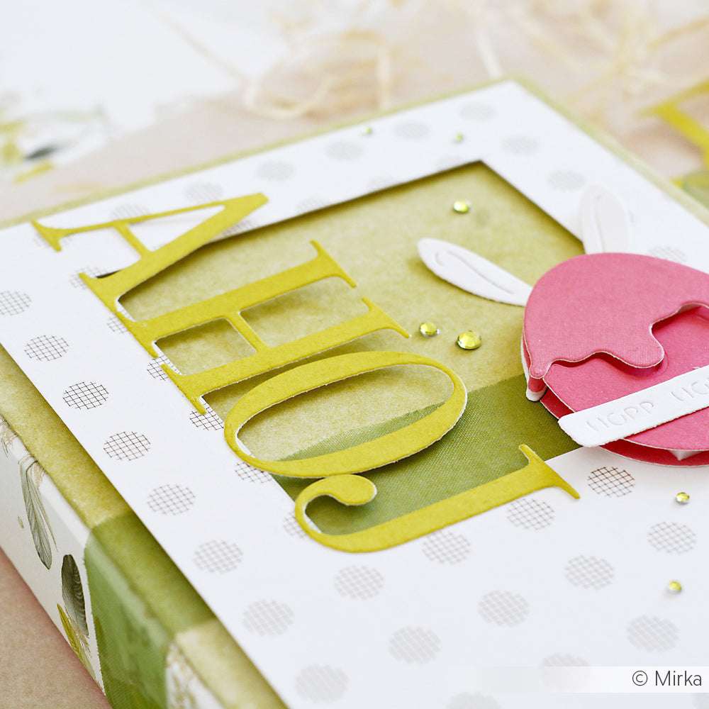 Handgefertigte Karte mit "Ahoi" in großen gelben Buchstaben, hergestellt mit Alexandra Renke Motivstanze Serifen Alphabet und DieCut Systemen, sowie einem rosa Hasenohrkreis auf gepunktetem Designpapier.