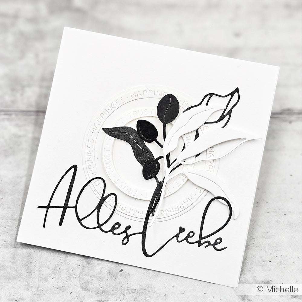 Weiße Karte mit schwarz-weißen Papierblättern aus Designpapieren von Alexandra Renke mit dem Schriftzug "Alles Liebe" in eleganter Schreibschrift - hergestellt mit der Motivstanze Alles Liebe für eine besondere Note.