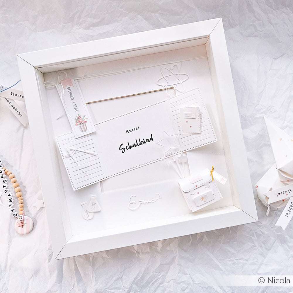 Eine weiße Schattenbox mit Papierbasteleien zum Thema Schule - Schulranzen, Lineal, Bleistift, Namensschilder und Akzente - gestaltet mit dem Alexandra Renke Clear Stamp Set Schulkind für kreative Details.
