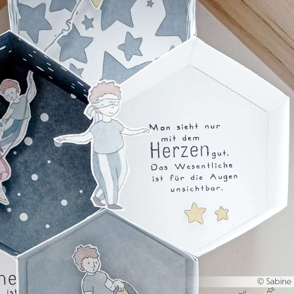 Handgezeichnete Figur mit Augenbinde neben deutschem Text in einem sechseckigen Kasten mit Sternmustern von Alexandra Renke, ideal für Ihre Clear Stamp Set oder Photopolymer Stempel Kollektion.