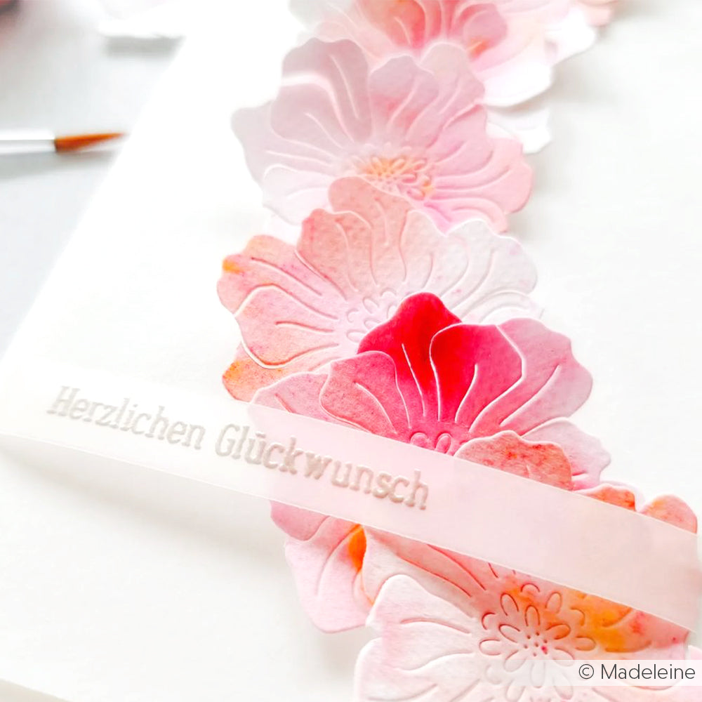 Wunderschöne rosafarbene Papierblumen mit einem durchscheinenden "Herzlichen Glückwunsch"-Streifen von Alexandra Renke sind kunstvoll auf weißem Papier arrangiert - ideal zum Basteln von Karten oder in Kombination mit Ihrem Lieblings-Photopolymer-Stempel.