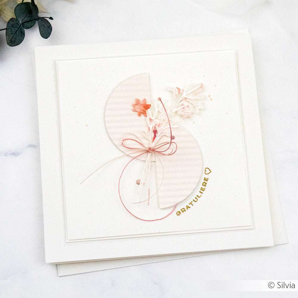 Quadratische Karte von Alexandra Renke mit rosafarbenen und weißen Blumenverzierungen, goldenem "Gratuliere"-Text und minimalistischem Design - veredelt mit einem Clear Stamp für stilvolle Grüße wie "Herzlichen Glückwunsch".
