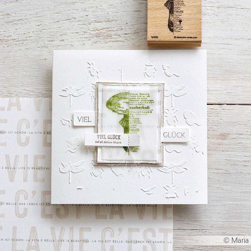 Handgefertigte Karte von Alexandra Renke mit geprägten Libellen, grünem Pilzmotiv und "Viel Glück" German Clear Stamp auf weißem Papier.