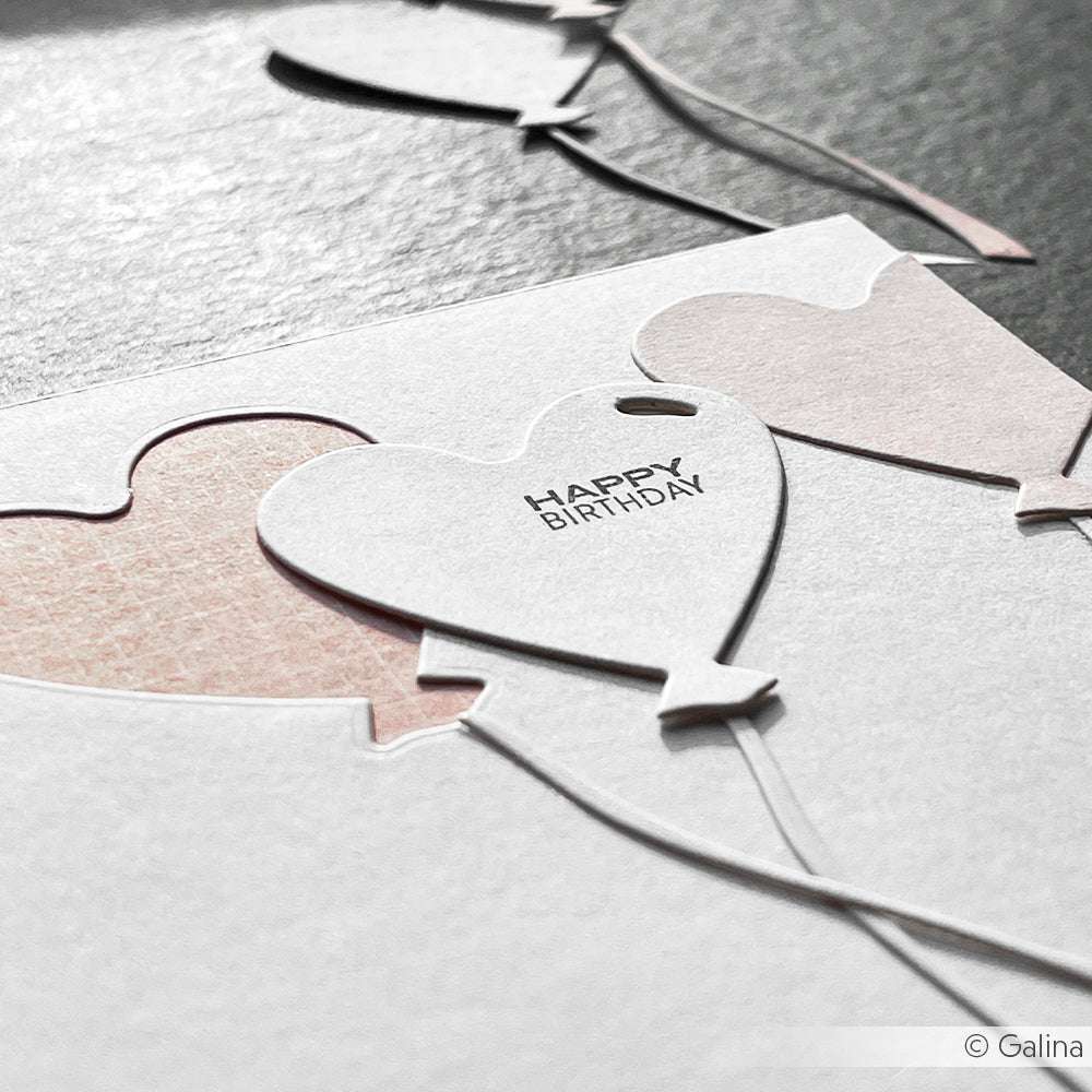 Nahaufnahme einer Geburtstagskarte mit herzförmigen Ballonausschnitten und dem Text "HAPPY BIRTHDAY" auf einem Ballon, der mit einem klaren Photopolymer-Stempel von Alexandra Renke hergestellt wurde, der für klare, elegante Details sorgt.