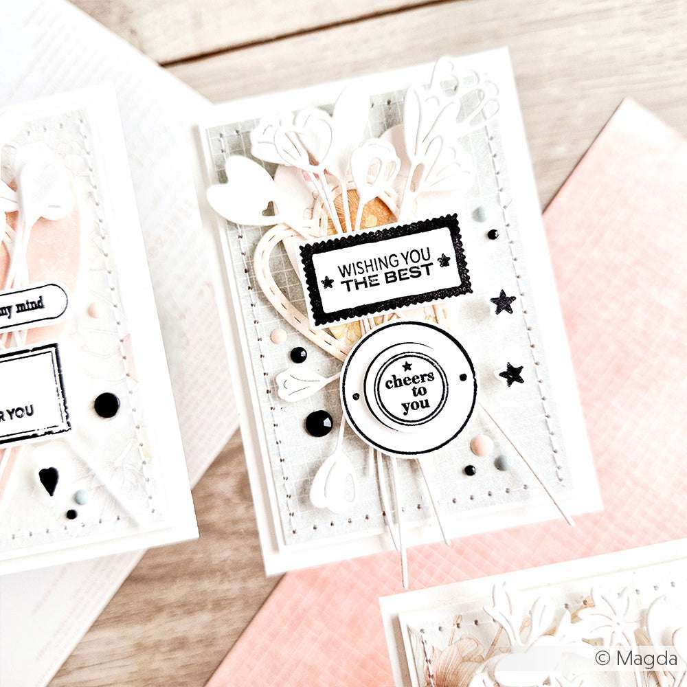 Handgefertigte Karte mit weißen und schwarzen Akzenten, Blumenausschnitten und dem Spruch "Ich wünsche dir alles Gute und Prost". Mit klaren Stempelmotiven von Alexandra Renke für eine einzigartige, elegante Note.