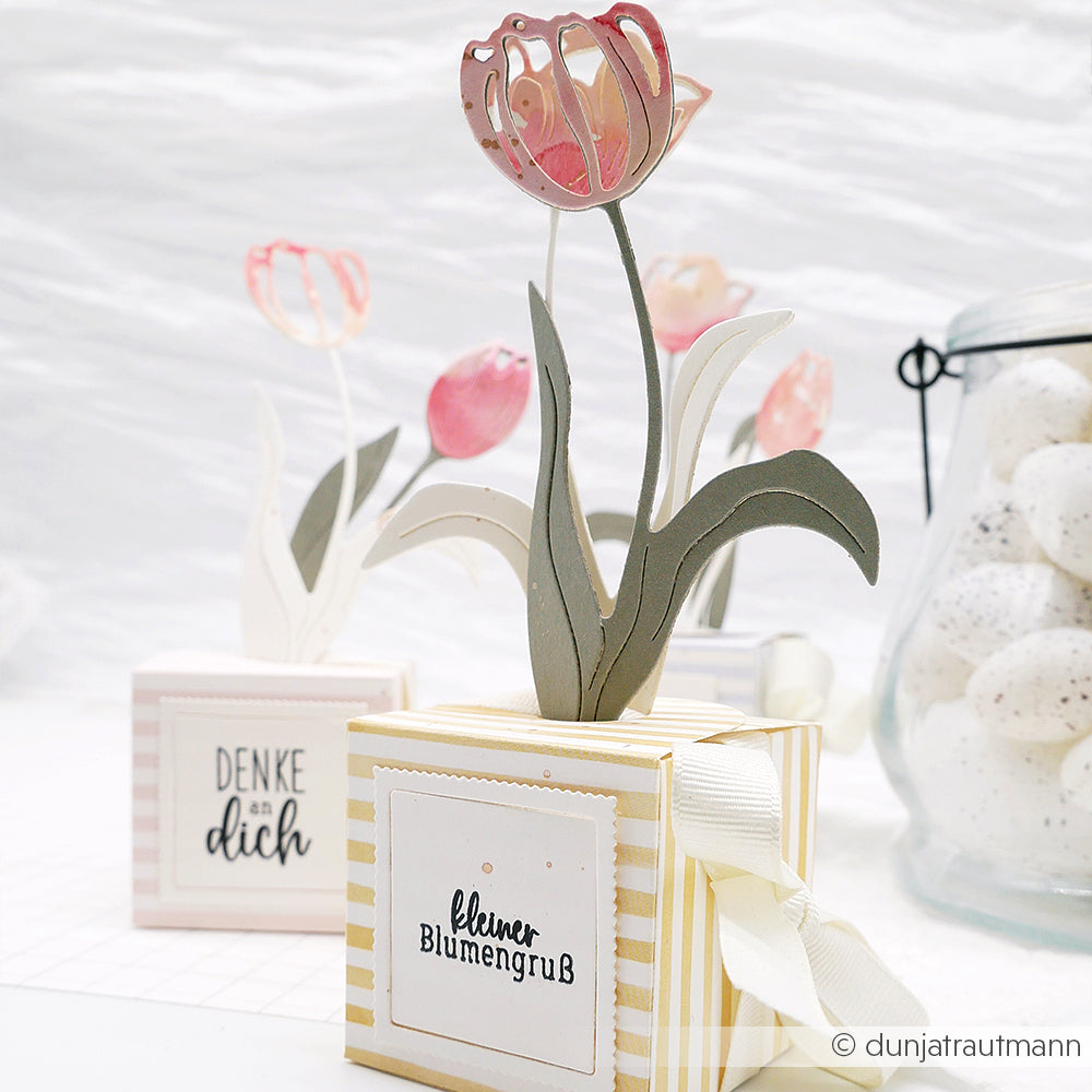 Alexandra Renke Papier-Tulpen in dekorativen Schachteln mit deutschem Text wie "Blumen für dich" sitzen neben einem Glas mit weiß gesprenkelten Eiern - perfekte Akzente, die Sie mit Ihren bevorzugten Photopolymer- oder Clear Stamps kombinieren können.