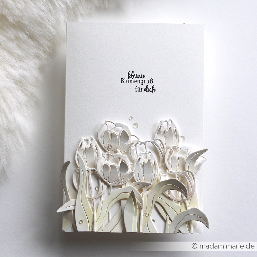 Weiße Karte von Alexandra Renke mit zarten 3D-Tulpenausschnitten und dem Text "Kleiner Blumengruß für dich", ideal für die Kombination mit Ihren Lieblings-Blumen Stempeln oder Clear Stamps, um einen einzigartigen Blumengruß zu gestalten.