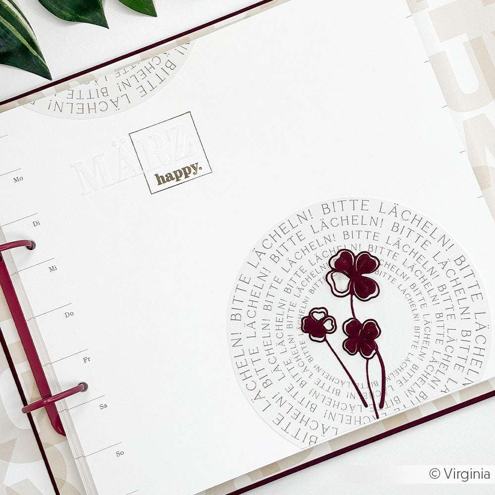 Offene Planerseite für März mit Alexandra Renkes Blumenkunst, dem Text "happy." und dem wiederholten deutschen Satz "Bitte lächeln!", gestempelt mit Photopolymer und Clear Stamps für klare Details.