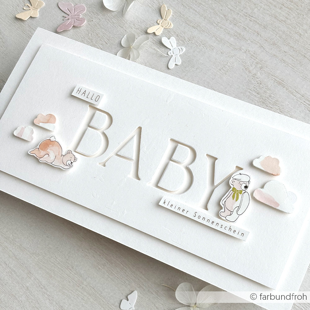 Weiße Karte von Alexandra Renke mit "Hallo BABY"-Text, Tierillustrationen und pastellfarbenen Papierwolken, gestaltet mit der Motivstanze Alphabet Dezember und hochwertigen Designpapieren für eine charmante Note.