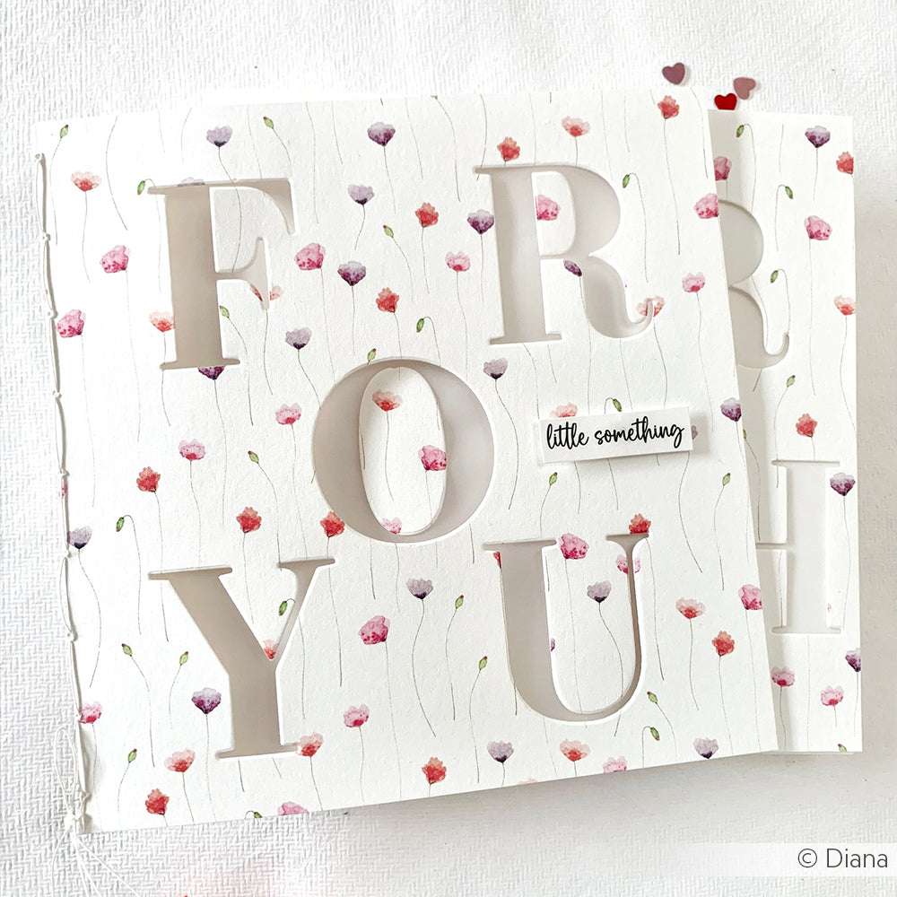 Handgemachte Karte von Alexandra Renke mit der Motivstanze Alphabet Groß ausgeschnitten "FOR YOU", einem floralen Designpapiere-Hintergrund und einem "little something"-Etikett.