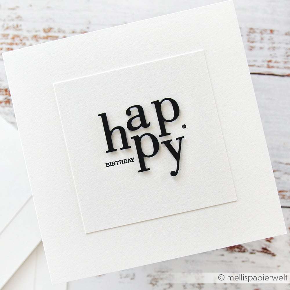 Weiße Geburtstagskarte von Alexandra Renke mit "Happy Birthday" in schwarzer, moderner Typografie auf weißem, strukturiertem Hintergrund, hergestellt aus hochwertigen Designpapieren für einen eleganten Touch.