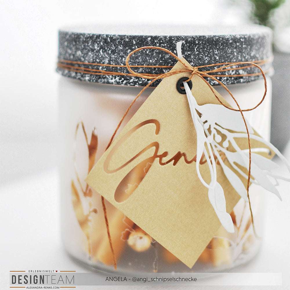 Ein gefrostetes Glas mit gesprenkeltem Deckel von Alexandra Renke, verschnürt mit Garn und einem braunen Genieß"-Anhänger - perfekt zum Kombinieren mit Motivstanze-Akzenten oder Ihren Lieblingsdesignpapieren.
