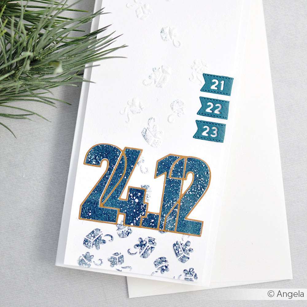 Weiße Karte mit großem blauen "24.12." und kleineren blauen Datumsschildern "21", "22" und "23", die mit den Stanzformen von Alexandra Renke hergestellt wurden; daneben ein Tannenzweig.