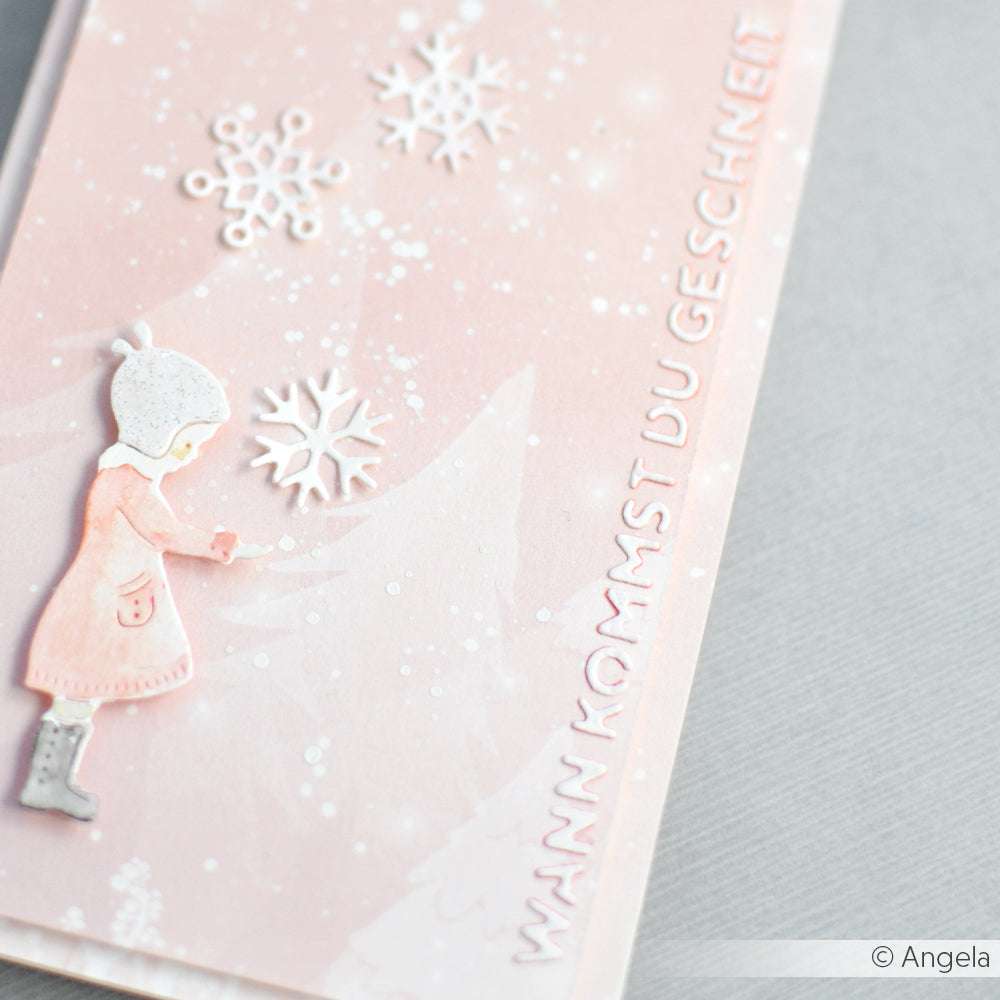 Rosa Karte mit einem Mädchen in Winterkleidung, Schneeflocken von Alexandra Renke Motivstanze Schneeflöckchen, und deutschem Text "WANN KOMMST DU U GESCHNEIT." Perfekt zum Basteln mit DieCut Systemen und 200g Designpapieren.