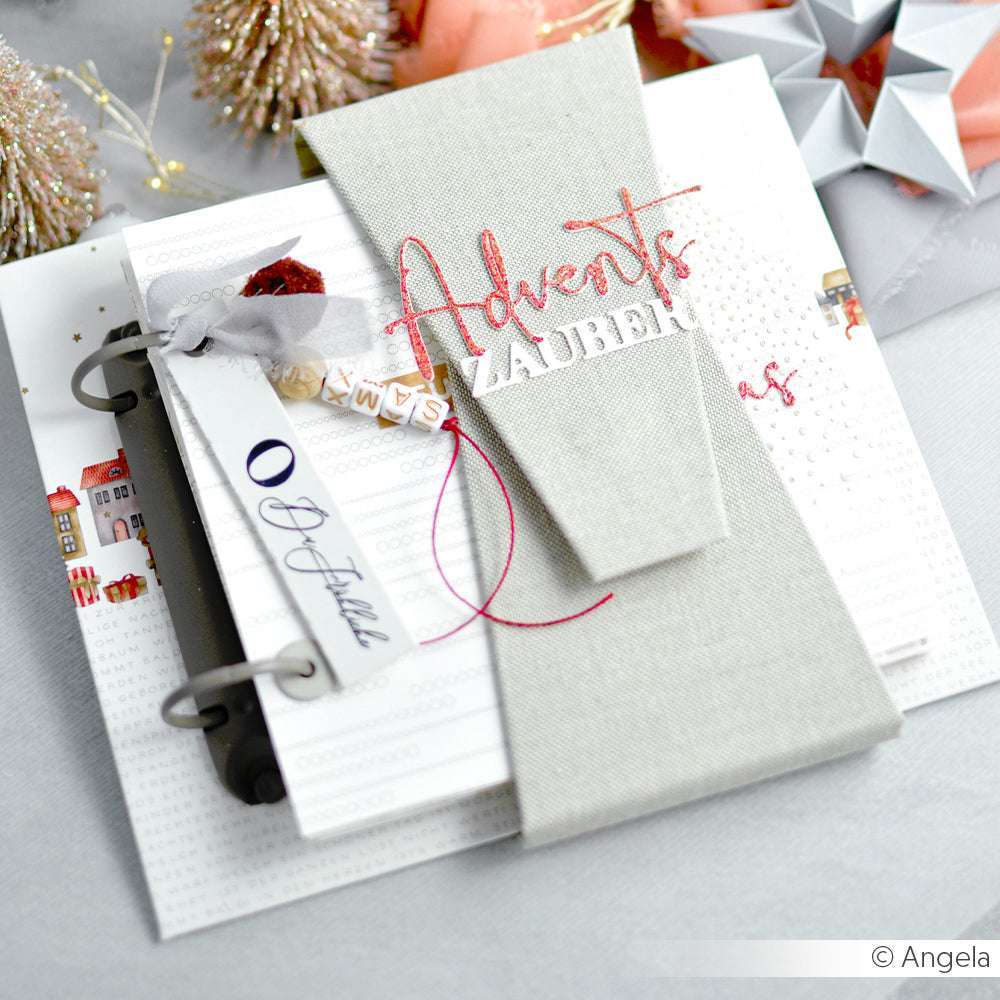 Eleganter, handgefertigter Adventskalender mit festlichen Dekorationen, hergestellt mit Alexandra Renke Stanzen für Designpapier und einem Anhänger, in neutralen und roten Tönen auf weißem Hintergrund.