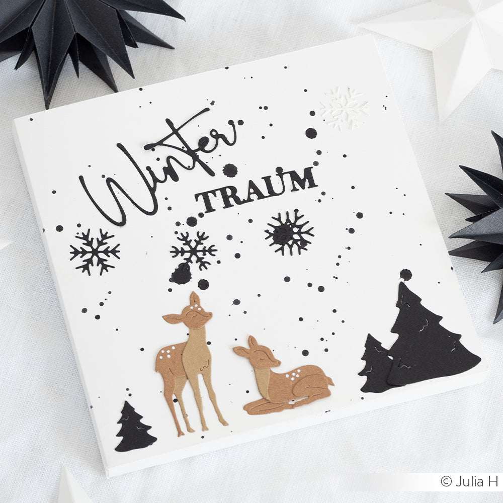 Eine winterliche Karte von Alexandra Renke mit zwei Rehen, schwarzen Bäumen, Schneeflocken und "Winter TRAUM" in schwarzer Schrift, gestaltet mit Motivstanze Wintermärchen für einen zauberhaften Touch.