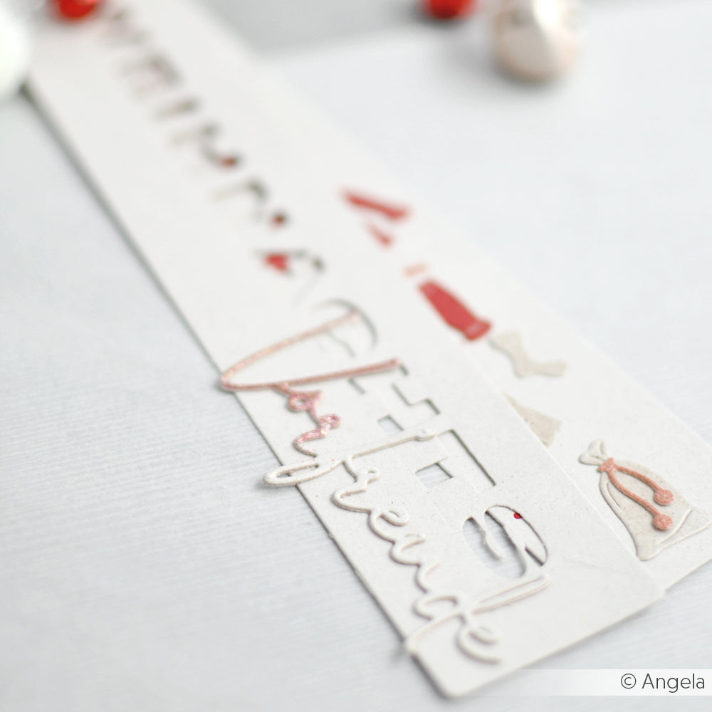 Nahaufnahme eines weißen, gestanzten Papierlesezeichens von Alexandra Renke mit dem Schriftzug "Different" und kleinen rosa und roten Ziermotiven.