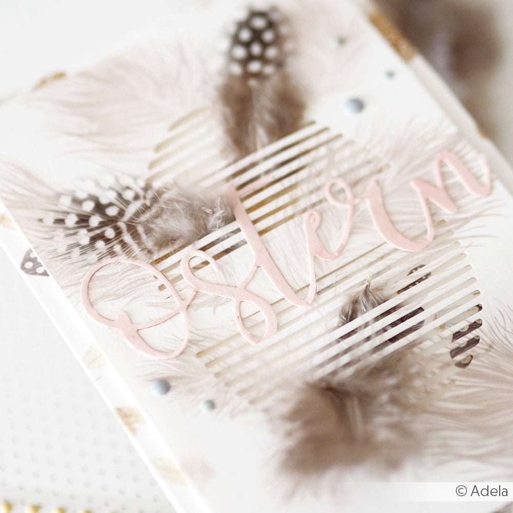 Zarte Osterkarte von Alexandra Renke mit pastellfarbenem "Ostern"-Schriftzug, zarten Federn, strukturiertem weißem Hintergrund, Designpapier-Akzenten und einer charmanten Motivstanze Frohe Ostern als Detail.