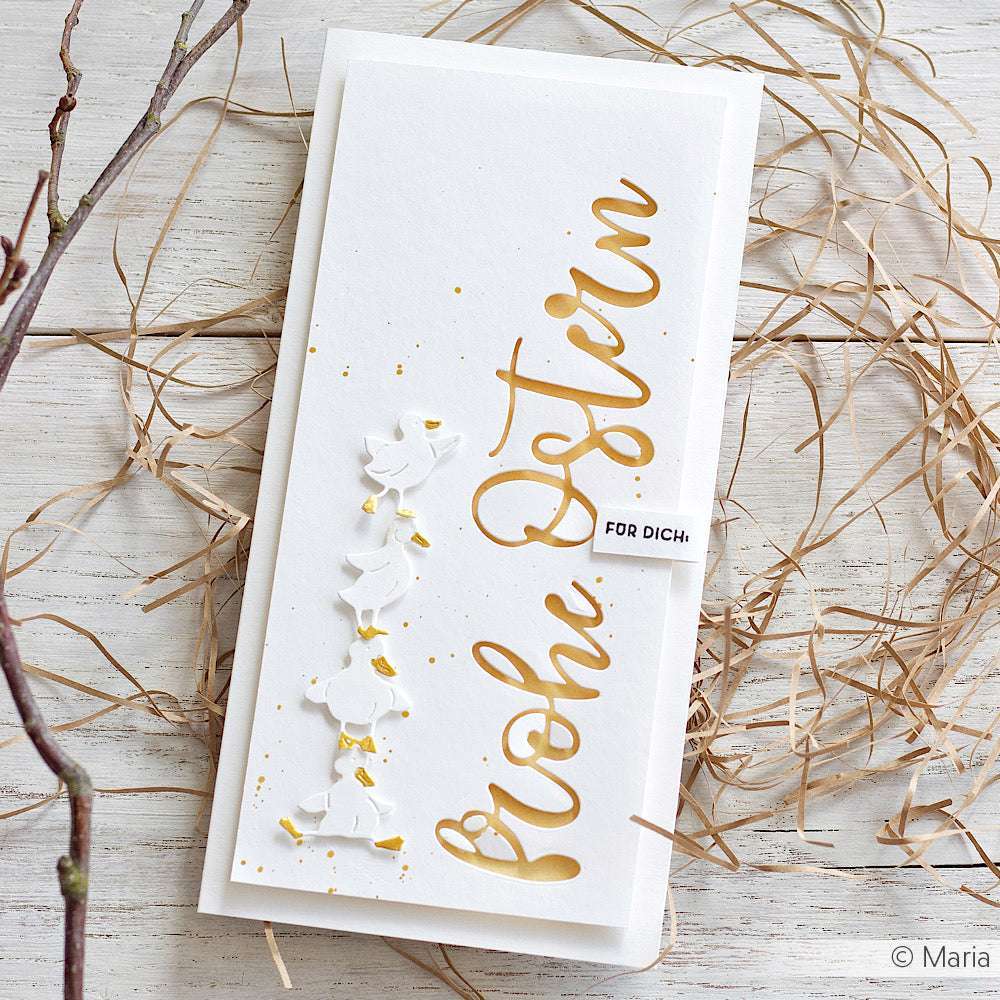 Weiße Osterkarte von Alexandra Renke mit goldenem "Frohe Ostern"-Text, weißen Tauben und Stroh auf hellem Holz - hergestellt aus hochwertigen 200g Designpapieren für ein elegantes Finish.