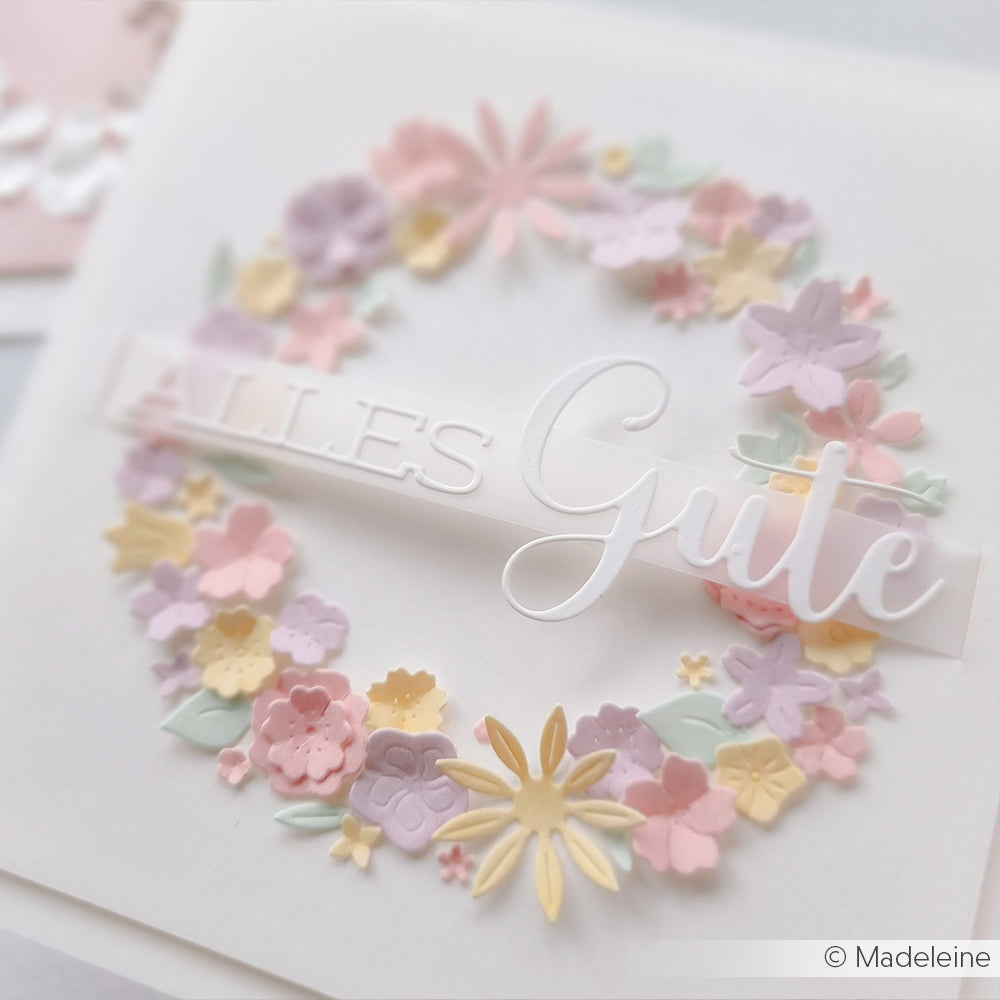 Ein pastellfarbener Blumenkranz mit dem Schriftzug Alles Gute" ziert eine weiße, quadratische Karte, die mit dem Motivstanze Schriften-Duo Alles Gute von Alexandra Renke präzise beschriftet und mit Alexandra Renke Designpapieren elegant gestaltet wurde.