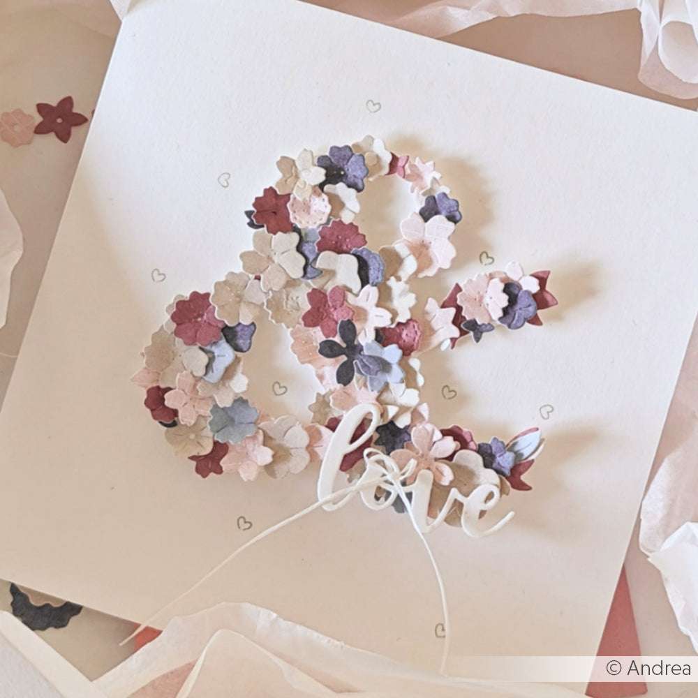 Eine Karte mit einem kaufmännischen Und-Zeichen aus pastellfarbenen Blumenausschnitten und "Liebe" in Schreibschrift, hergestellt mit Alexandra Renke Stanzsysteme Dies und dem Motivstanze Schriften-Duo Love You.