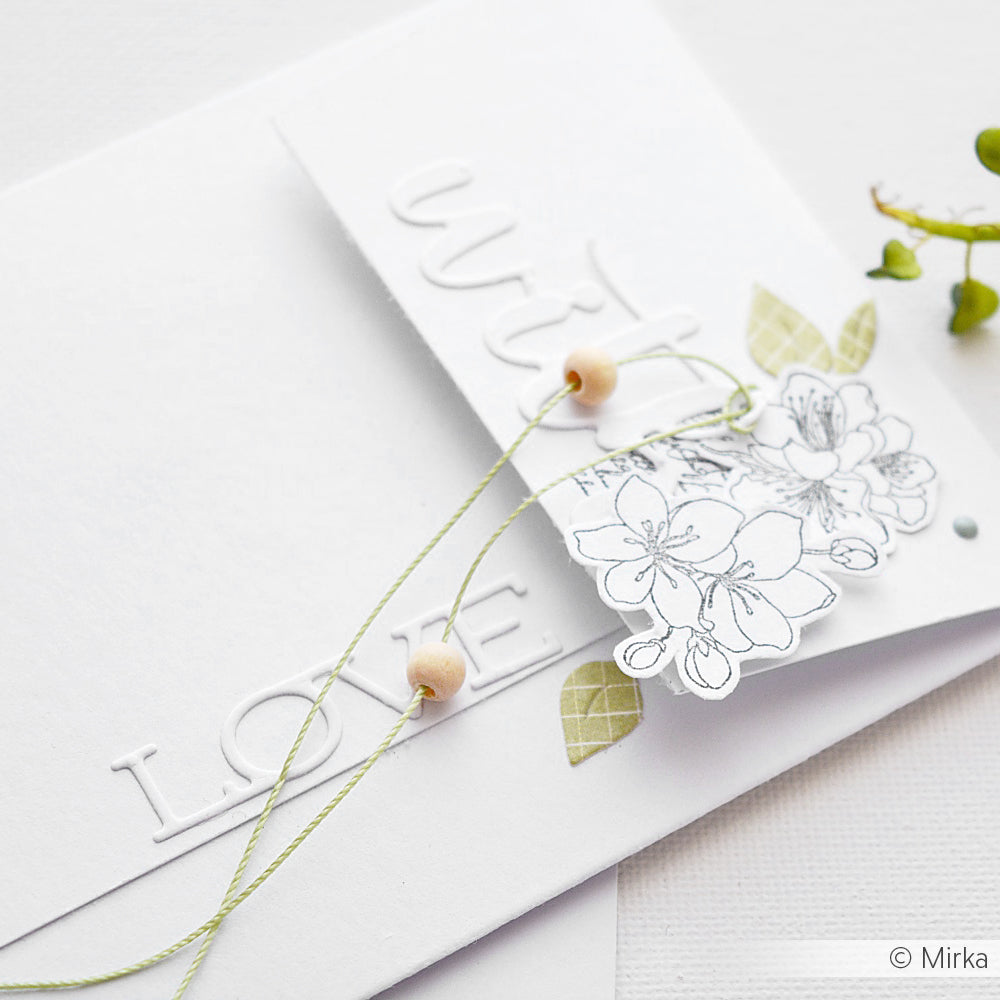 Weiße handgefertigte Karte von Alexandra Renke mit LOVE-Text aus dem Motivstanze Schriften-Duo Love You, verziert mit einer floralen Skizze, grüner Schnur, Holzperlen, Blattakzenten und hochwertigen Designpapieren für ein charmantes Finish.