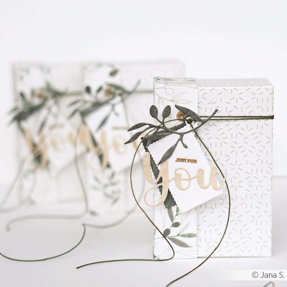 Weiße Geschenkschachteln mit Blattakzenten, "Just for You"-Anhängern und grünen Rankenschleifen - perfekt für Ihr nächstes Projekt mit dem Alexandra Renke Motivstanze Schriften-Duo oder anderen Dies für Papierbasteln.