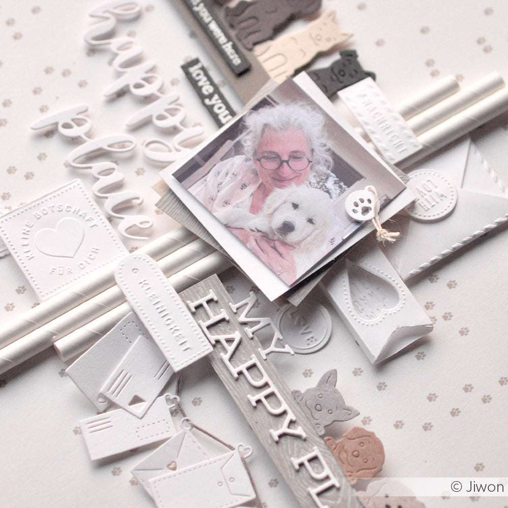 Eine Frau lächelt, während sie einen weißen Hund hält, umgeben von Alexandra Renke Designpapieren und Schriften-Duo My Happy Place Papierbasteleien.