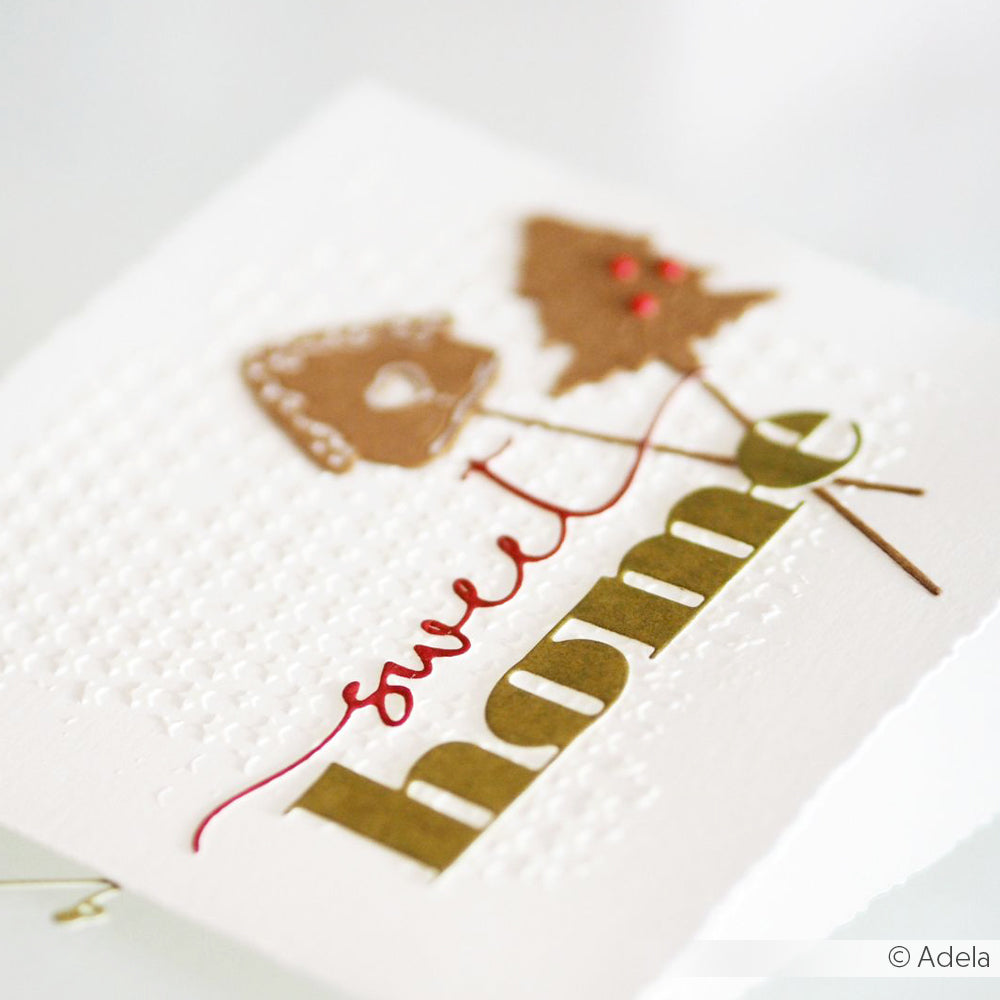 Handgemachte Karte von Alexandra Renke mit dem Text "Home sweet home", einem Baum und einem Hausausschnitt auf strukturiertem weißem Papier, hergestellt mit Stanzsystemen für präzise Details.