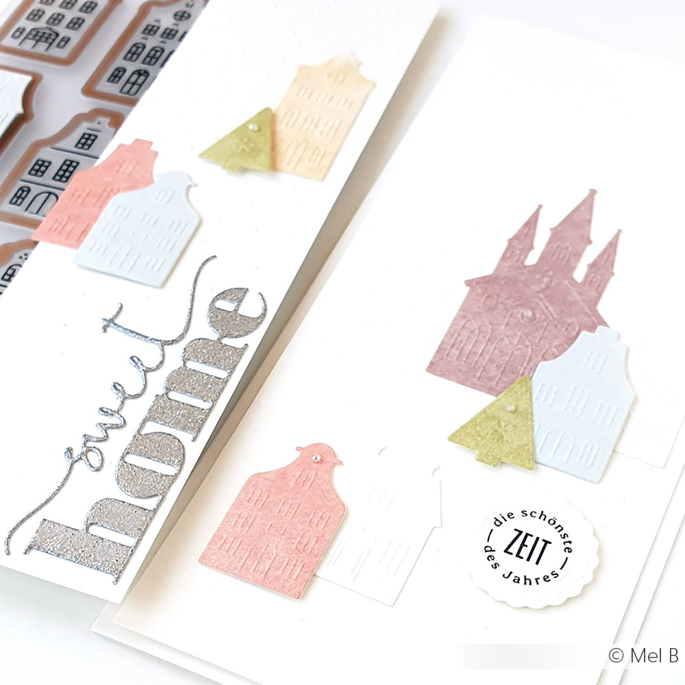 Weiße Karten von Alexandra Renke mit pastellfarbenen, geprägten Häusern, Bäumen, einem Text "Sweet Home" und einem runden, gestempelten ZEIT-Akzent - hergestellt mit Motivstanze Wörterset und Stanzen für Designpapier für charmante Details.