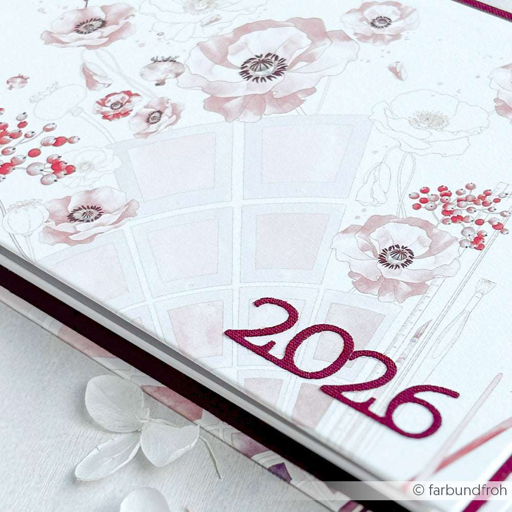 Ein Planer 2026 von Alexandra Renke mit roten Blumenillustrationen, zarten rosa und roten Akzenten und eleganten Details, inspiriert von Motivstanze Kleine Serifenzahlen und hochwertigen Designpapieren.
