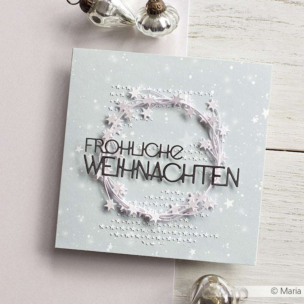 Quadratische Karte von Alexandra Renke mit "Fröhliche Weihnachten" und einem dekorativen Sternenkranz auf hellem Sternenhintergrund, gefertigt aus Motivstanze Weihnachten und hochwertigen 200g Designpapieren für besondere Eleganz.