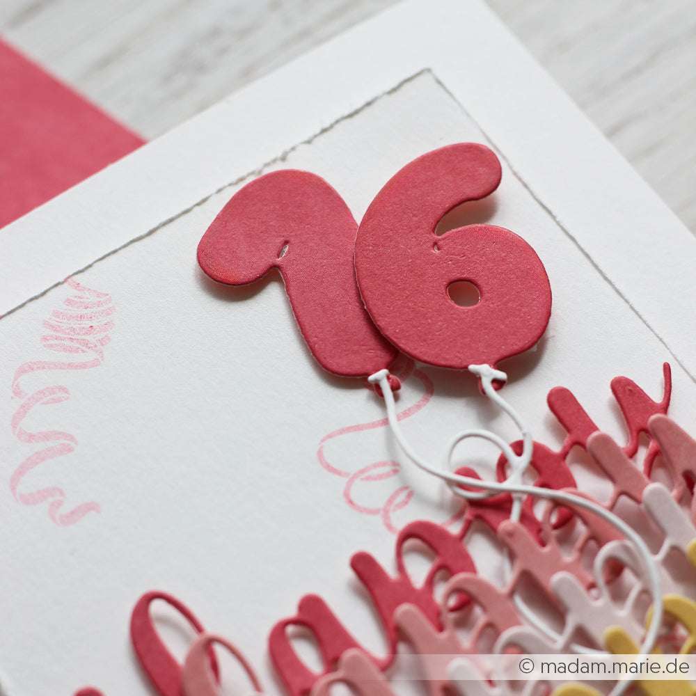 Nahaufnahme einer handgefertigten Karte mit "16" in Rosa, die mit einer Schnur befestigt ist, und darunter liegendem Text, der mit Alexandra Renke Deep Edge Motivstanzen für gestochen scharfe Details hergestellt wurde.