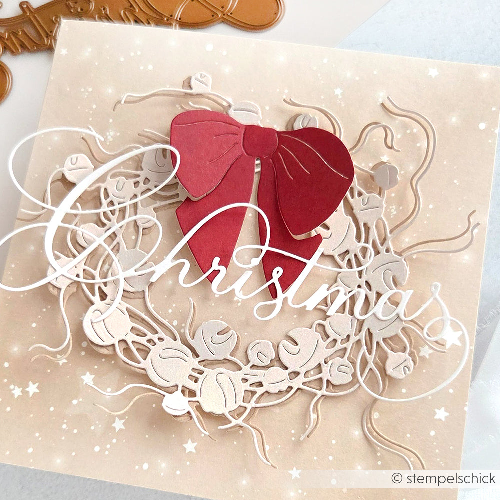 Handgefertigte Weihnachtskarte von Alexandra Renke mit roter Schleife, weißem Kranz und dem Schriftzug "Weihnachten", hergestellt mit hochwertigem Designpapier und einer DieCut Systeme Motivstanze Kalligrafisch Christmas für ein elegantes Finish.