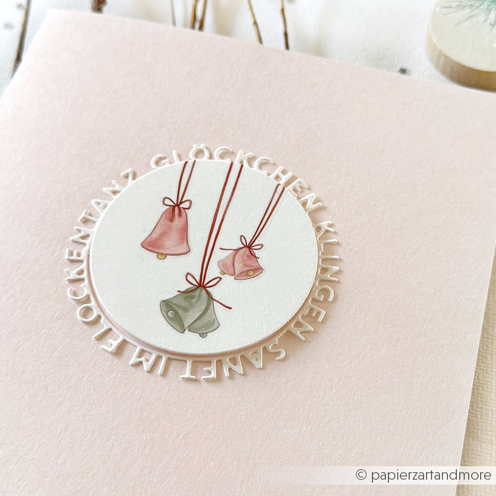 Handgefertigte Karte mit drei pastellfarbenen Glocken und kreisförmigem Text "Kling, Glöckchen, klingelingeling, Stille Nacht", hergestellt auf hochwertigem Designpapier mit der Motivstanze Glöckchen klingen von Alexandra Renke für präzise Details.