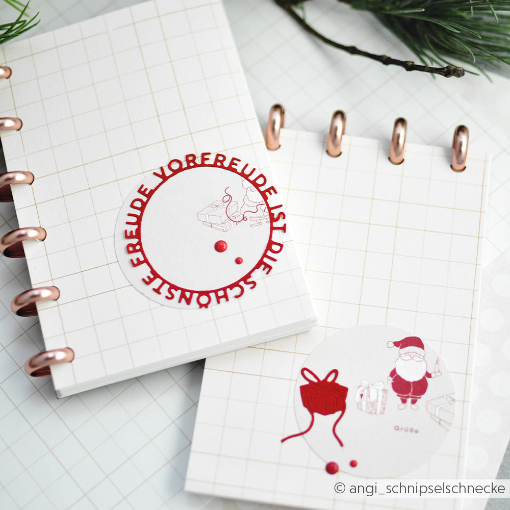 Zwei festliche Alexandra Renke-Notizbücher mit Weihnachtsmann- und Geschenkillustrationen mit roten Akzenten auf einem weißen Raster - perfekt für die Kombination mit Ihren Lieblingsstempeln oder Stanzsystemen für eine individuelle Weihnachtsgestaltung.