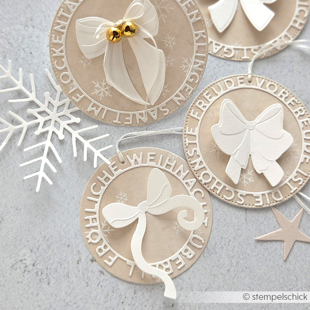 Vier festliche runde Anhänger mit weißen Schleifen und deutschen Weihnachtsgrüßen, die mit der Alexandra Renke Motivstanze Fröhliche Weihnacht gestaltet wurden, werden von einer Schneeflocke und einem Stern dargestellt - perfekt, um Ihre Weihnachtsgeschenke zu verpacken!.