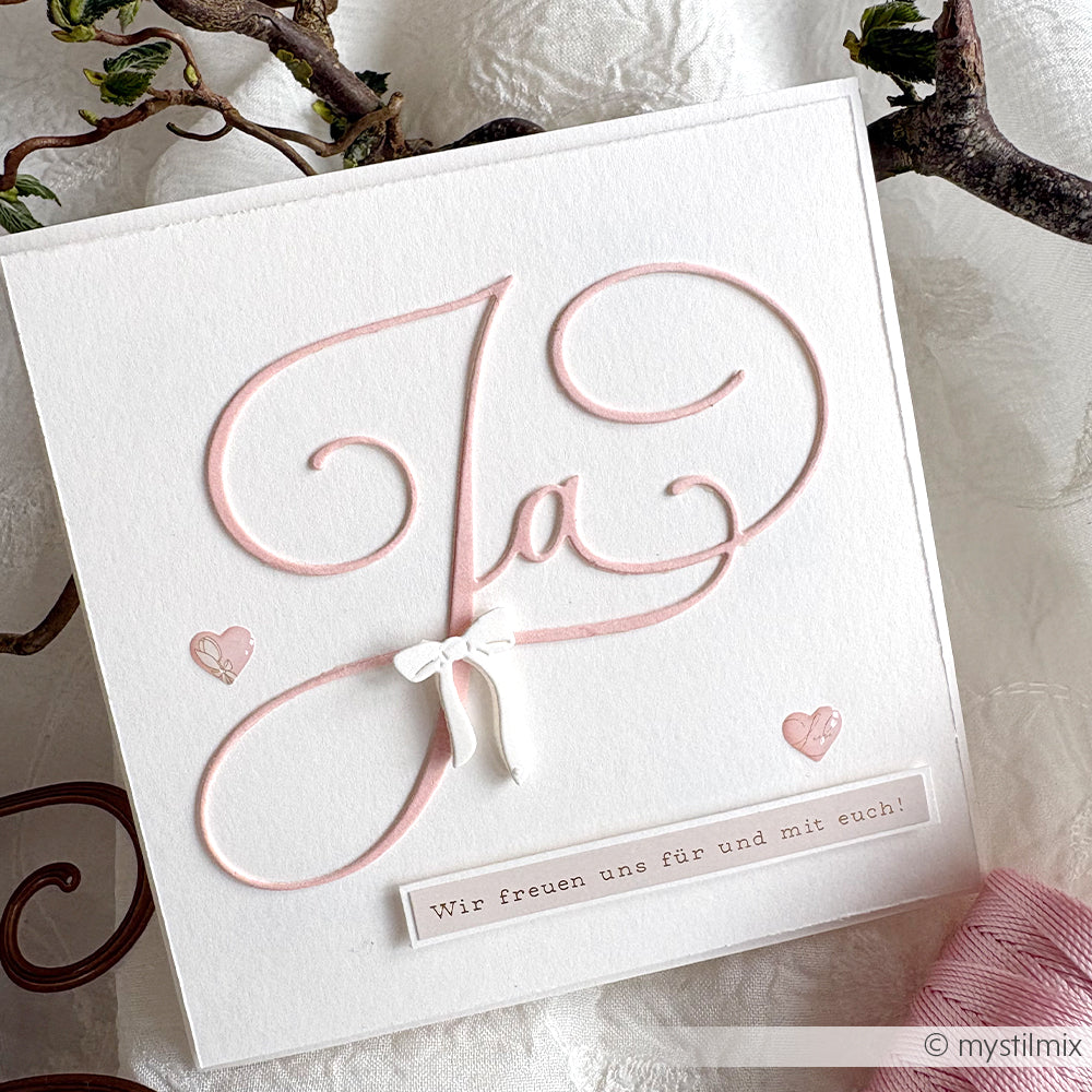 Weiße Hochzeitskarte von Alexandra Renke aus feinem Designpapier, mit rosa "Kalligrafisch Ja"-Schriftzug, kleinen Herzen und dem Text: Wir freuen uns für und mit euch!.