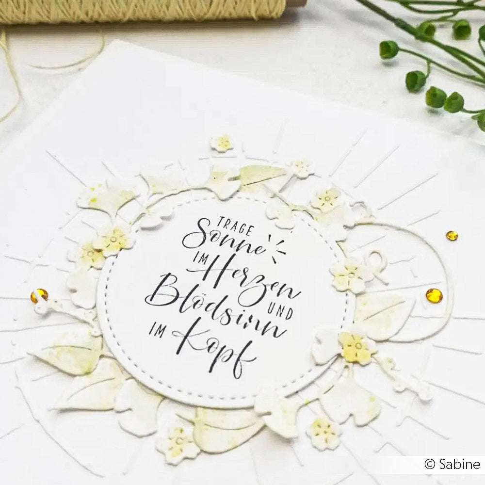 Weiße Karte von Alexandra Renke mit floralen Verzierungen und deutscher Kalligraphie in der Mitte, akzentuiert in Gelb - ideal für Papierprojekte oder zum Verschönern mit Ihren Lieblings-Stempelgummi oder Holzstempel-Motiven.