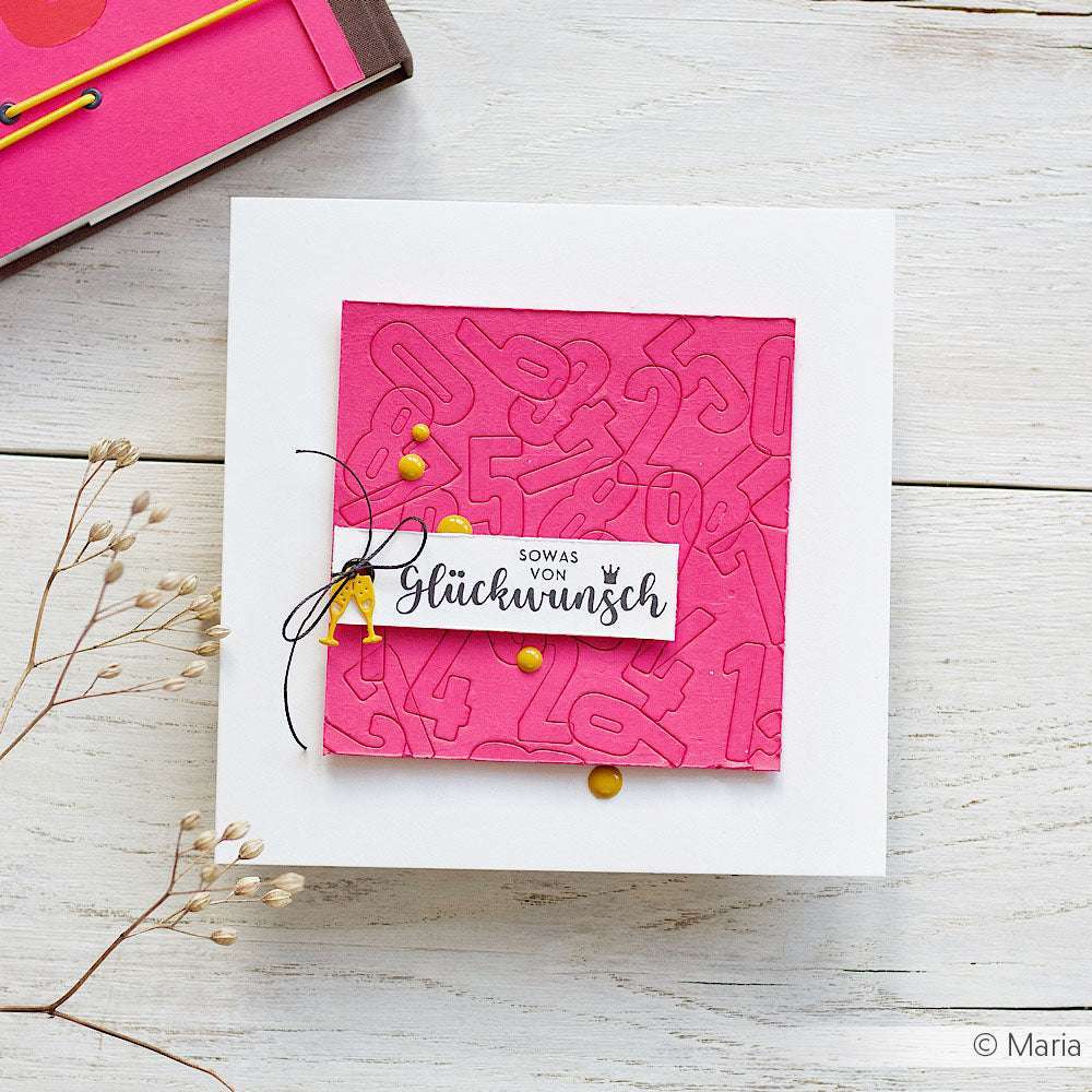 Quadratische Grußkarte von Alexandra Renke mit rosa geprägten Zahlen, gelben Punkten und einer deutschen Glückwunschbotschaft auf weißem Papierprojekte mit Edelholzstempeln.