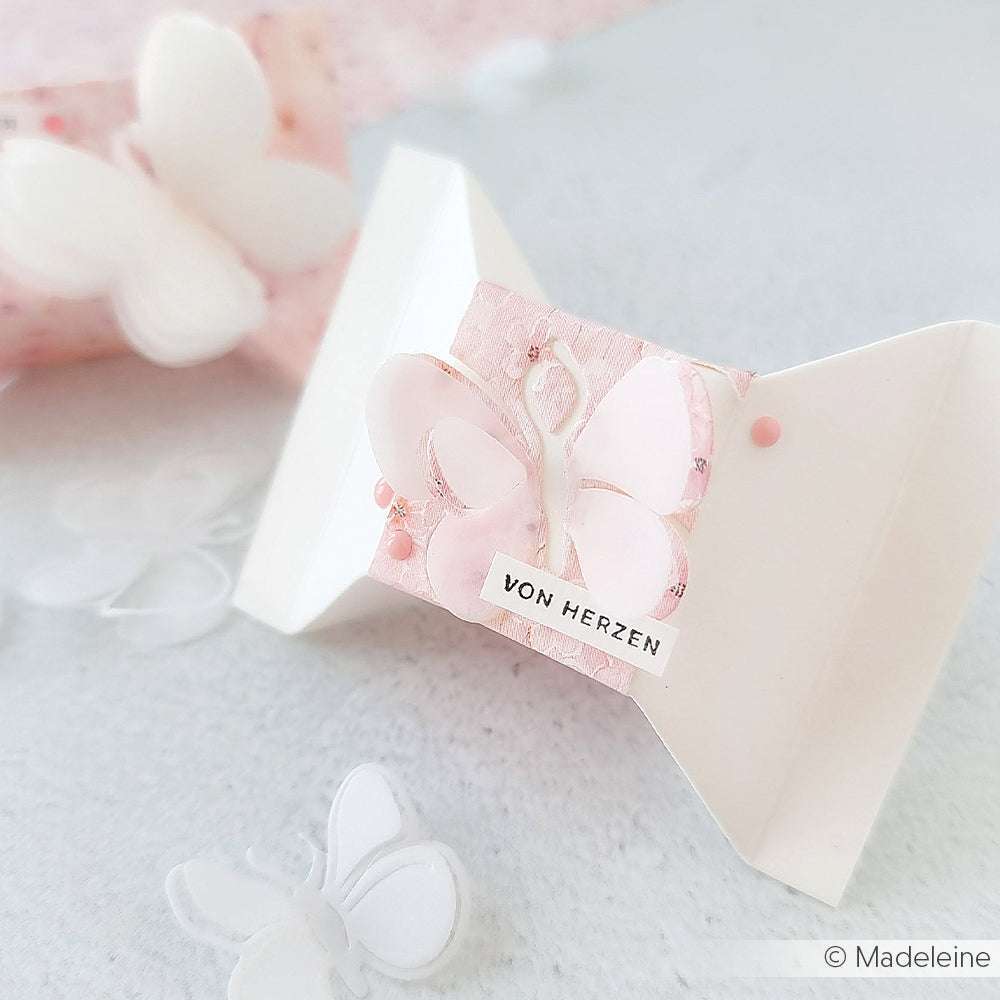 Weiße Papier-Geschenkbox von Alexandra Renke mit rosa Schmetterling, "VON HERZEN"-Etikett und Schmetterlingsausschnitten - ideal für Papierprojekte oder zur Präsentation von Geschenken mit Ihren Lieblings-Stempelgummi-Motiven.