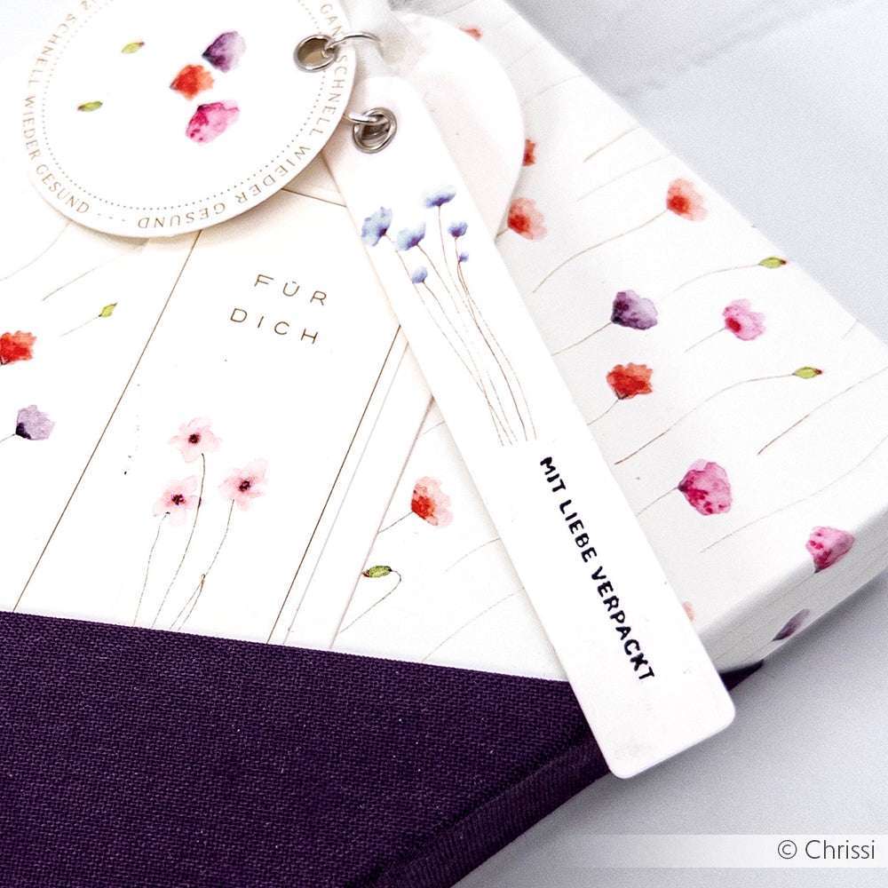 Das Geschenk ist in geblümtes Papier mit lilafarbenem Akzent eingewickelt, auf den Anhängern steht "Für Dich" und "Mit Liebe verpackt", und es ist mit einem Alexandra Renke Mini Typo Holzstempel gestempelt, der für eine charmante Note sorgt.