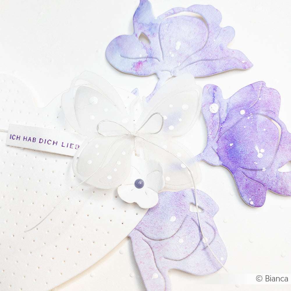 Ein weißer Schmetterling und lila Blüten zieren ein weißes Herz mit "Ich hab dich lieb" - ideal für die Kartendekoration mit Alexandra Renke Holzstempel oder Mini Typo Stempelgummi.