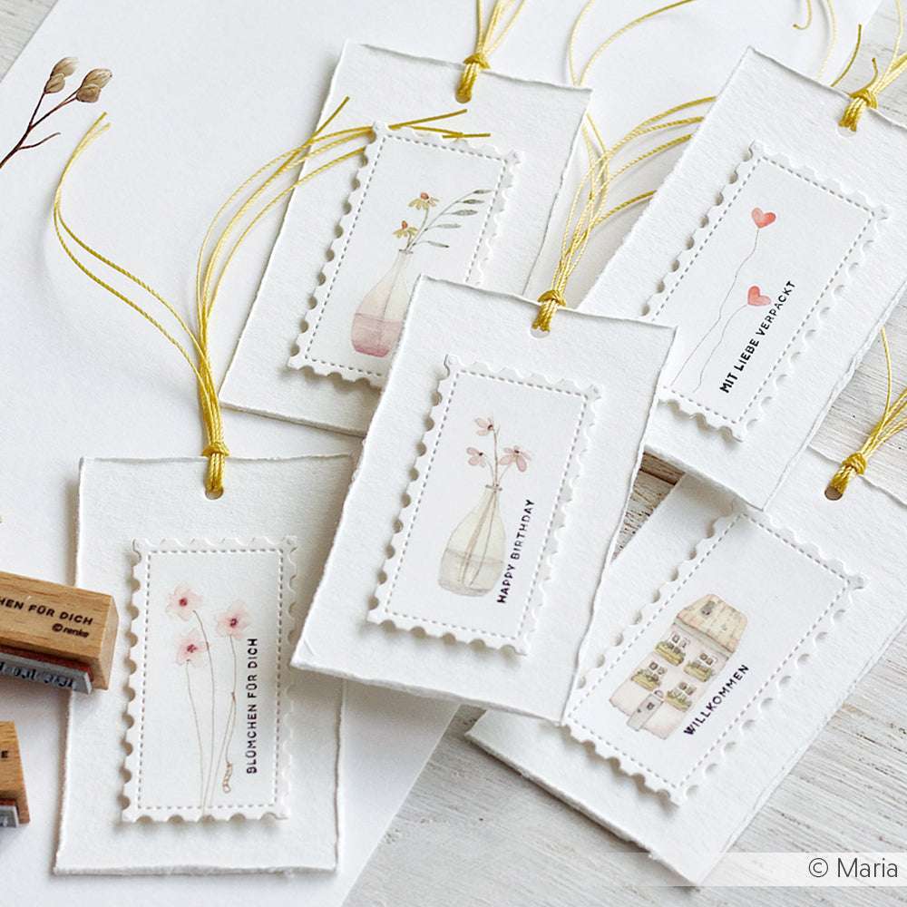 Sechs handgefertigte Geschenkanhänger von Alexandra Renke mit Blumen- und Geburtstagsmotiven, jeweils mit gelber Kordel gebunden - perfekt, um Ihren Lieblings-Holzstempel oder Stempel für Papierprojekte zu verwenden und eine persönliche Note zu verleihen.