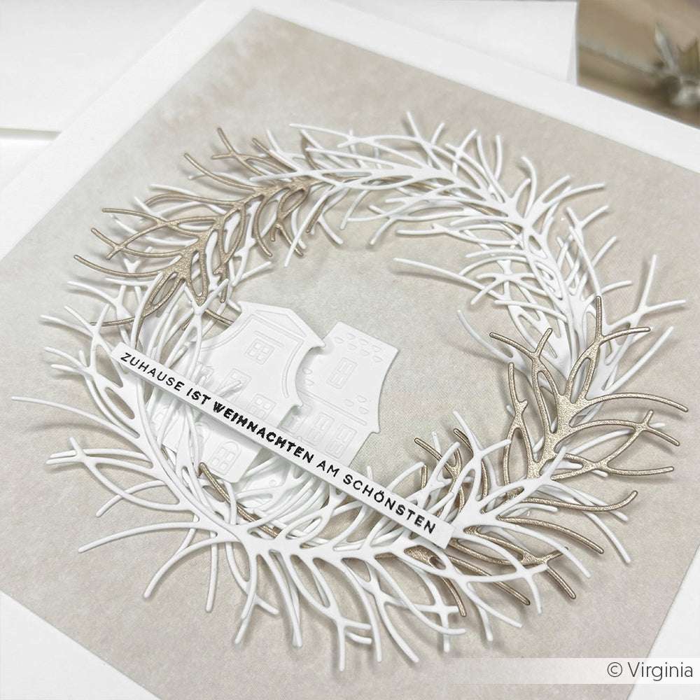 Ein zarter weiß-silberner Kranz von Alexandra Renke umgibt zwei kleine weiße Häuser und einen deutschen Weihnachtsgruß - eine ideale Karte, um sie mit Ihrem Lieblingsholzstempel oder Stempelkissen zu kombinieren.