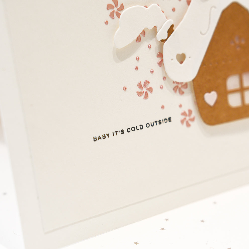 Grußkarte mit einem ausgeschnittenen Haus und dem Text BABY ITS COLD OUTSIDE für Papierbastelprojekte.